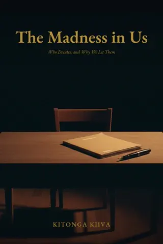 The Madness in Us — Who Decides, and Why We Let Them, by Kitonga Kiiva. Cover: a closed file and a pen on a lamp-lit desk, before an empty chair.